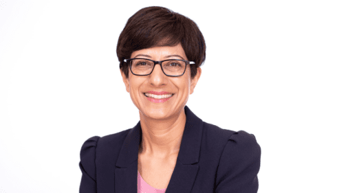 A professional photo of Katie Ghose, Kids CEO. She is wearing a dark blazer and eyeglasses.