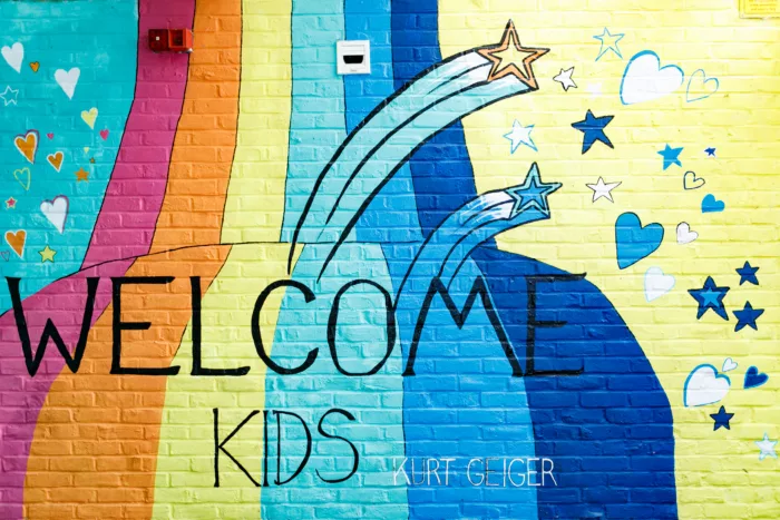 A painted wall at Hackney playground which reads, 'WELCOME KIDS'. The wall is multicoloured.
