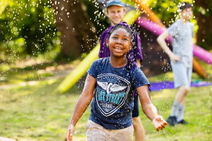 A young girl plays in the rain.