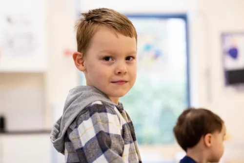 Photo of a boy's profile. His head is turned slightly to face the camera.
