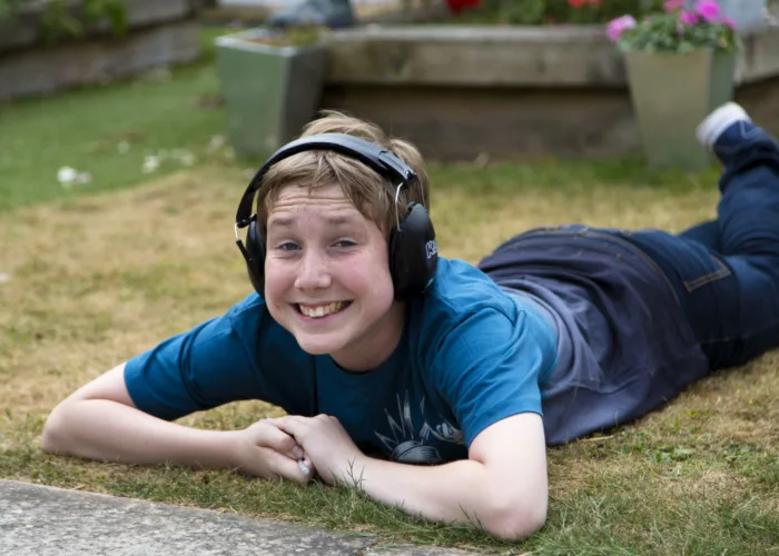 A boy lies on grass smiling