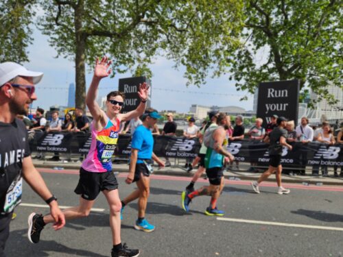 man running a marathon in a kids branded vest