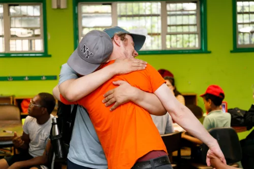 A staff and a young person are hugging at our Hackney Playground.