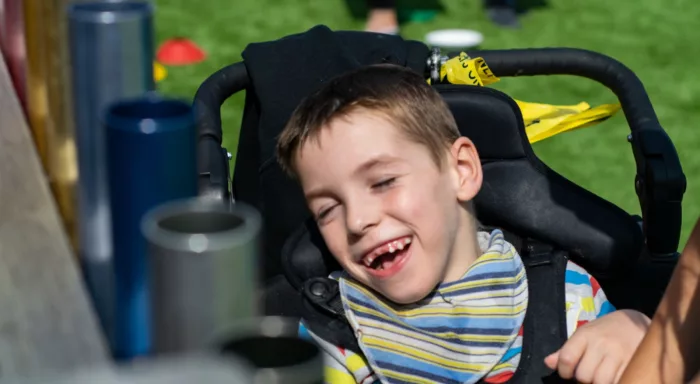 A boy in a chair smiles