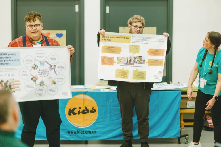 Young people holding up posters during a workshop