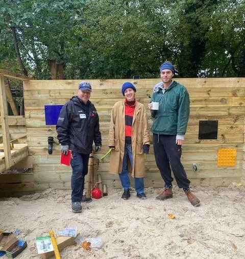 Three volunteers in the sandpit 