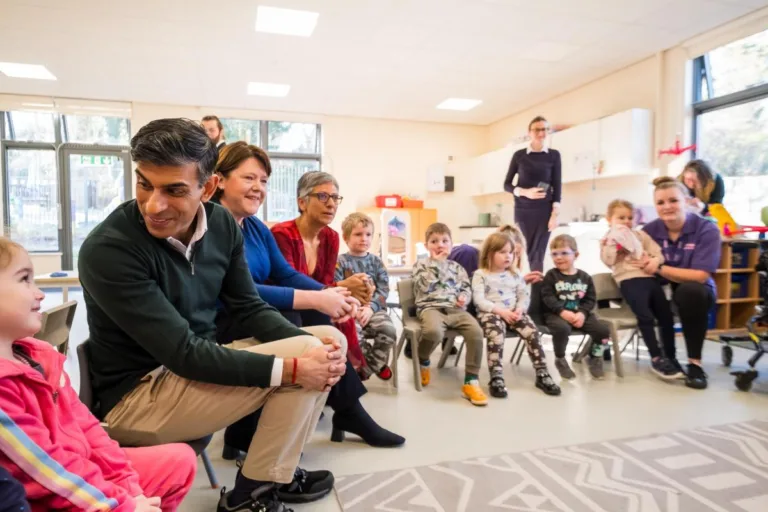 Prime Minister Rishi Sunak, Maria Miller MP, and Kids' Chief Executive, Katie Ghose, sit with children at Kids' Basingstoke Nursery