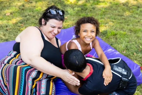 A family laughing together on a picnic blanket