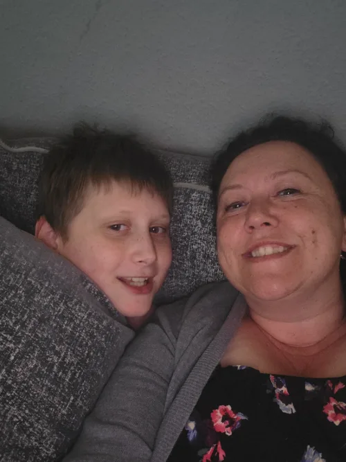Donna and her son are taking a selfie on the couch