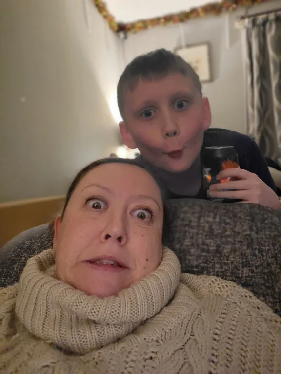 Donna and her son are taking a selfie while making funny faces