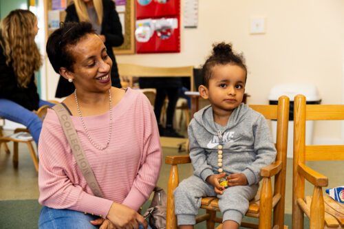 mum and young son sitting and smiling in a nursery