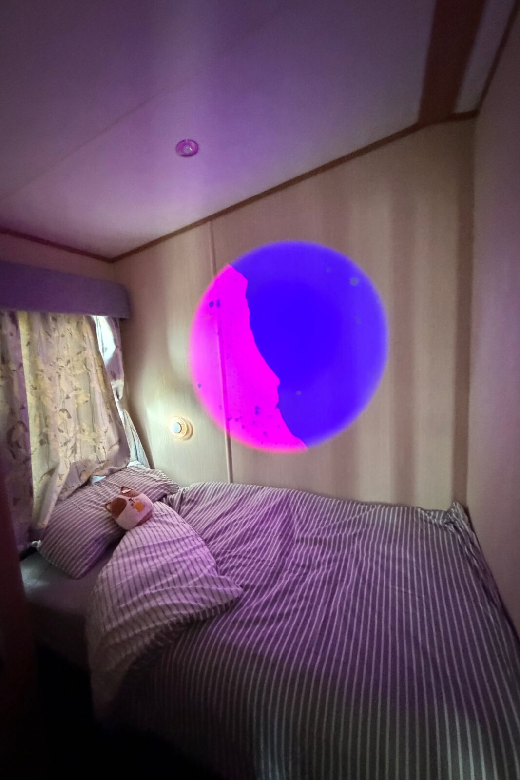 bedroom with projector on the wall in caravan