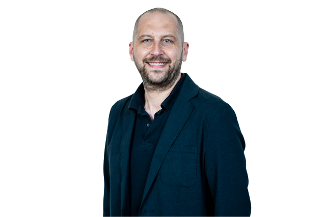 man wearing a blue suit jacket and blue polo shirt smiling