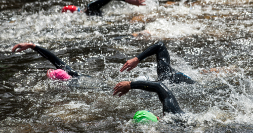 a group of people swim racing